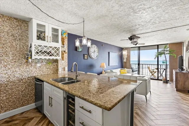 a kitchen with granite countertop a sink a counter space and stainless steel appliances