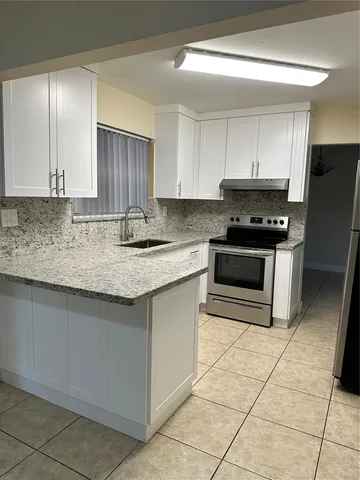 a kitchen with stainless steel appliances granite countertop a sink stove and cabinets