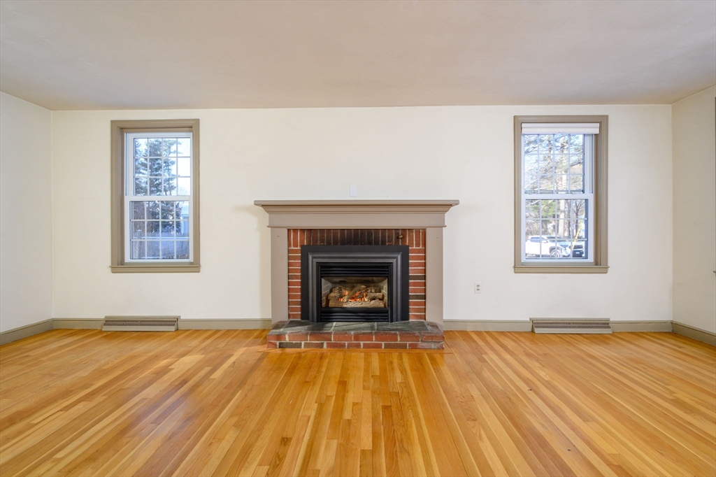 15 Autumn Circle Hingham, MA 02043 - Photo 11 of 38 a view of empty room with wooden floor and fireplace
