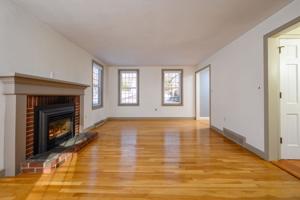 15 Autumn Circle Hingham, MA 02043 - Photo 10 of 38 a view of empty room with wooden floor fireplace and window