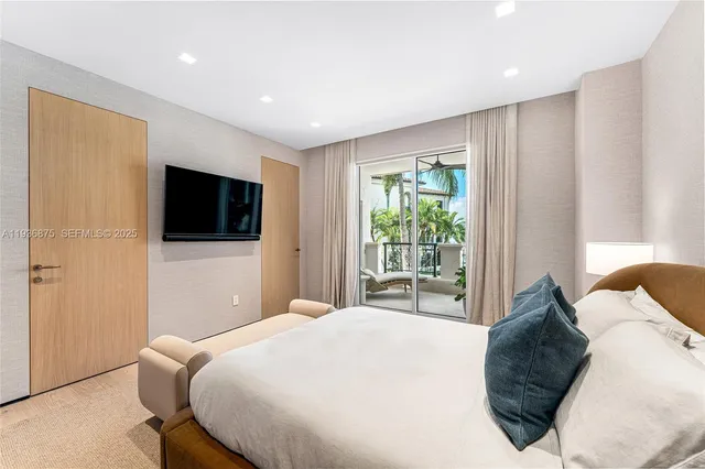 a bedroom with a large bed and a flat screen tv