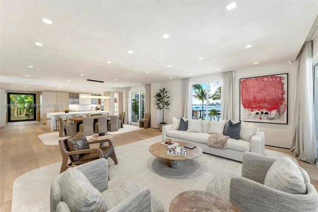 a living room with furniture kitchen view and a large window