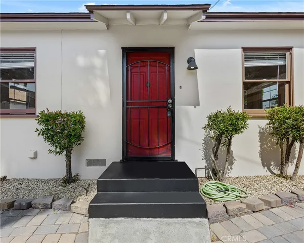 a vase of flowers sitting on a table in front of a house