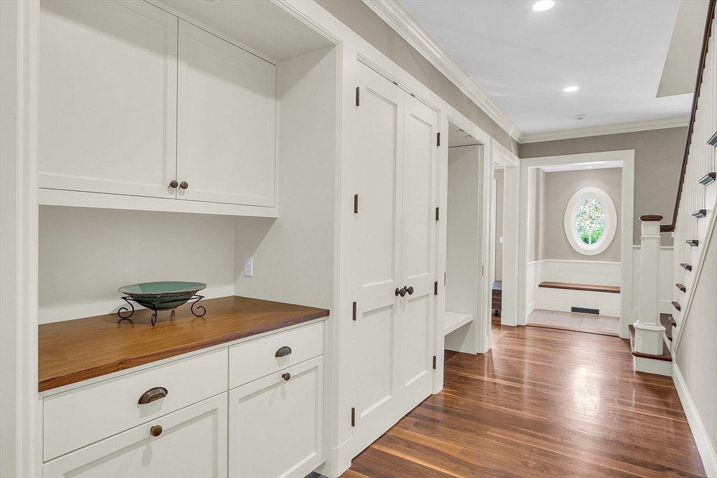 247 Independence Road Concord, MA 01742 - Photo 23 of 42 a hallway with white cabinets and wooden floor