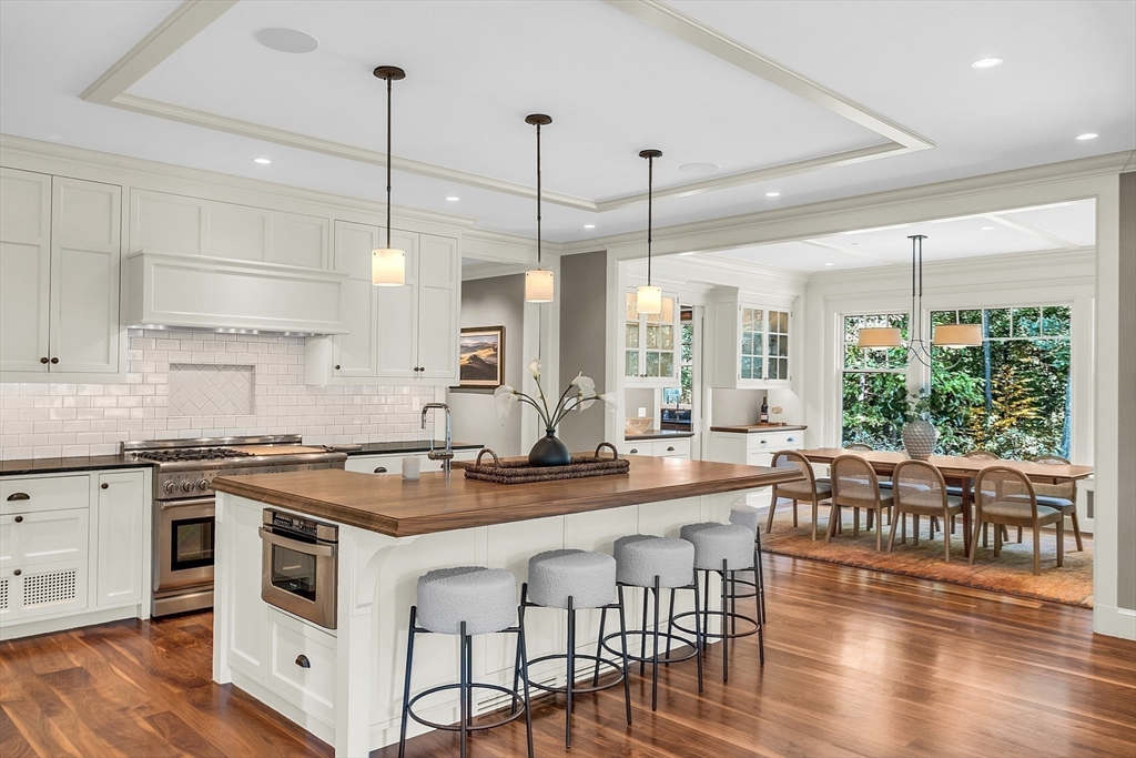 247 Independence Road Concord, MA 01742 - Photo 7 of 42 a kitchen with stainless steel appliances granite countertop a stove a sink a center island with wooden floor and cabinets
