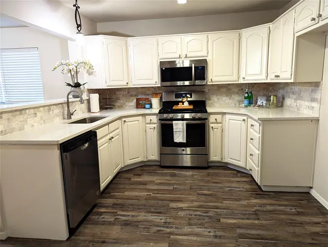 a kitchen with stainless steel appliances granite countertop a sink and cabinets