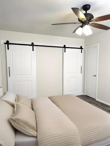 a bedroom with a bed and a ceiling fan