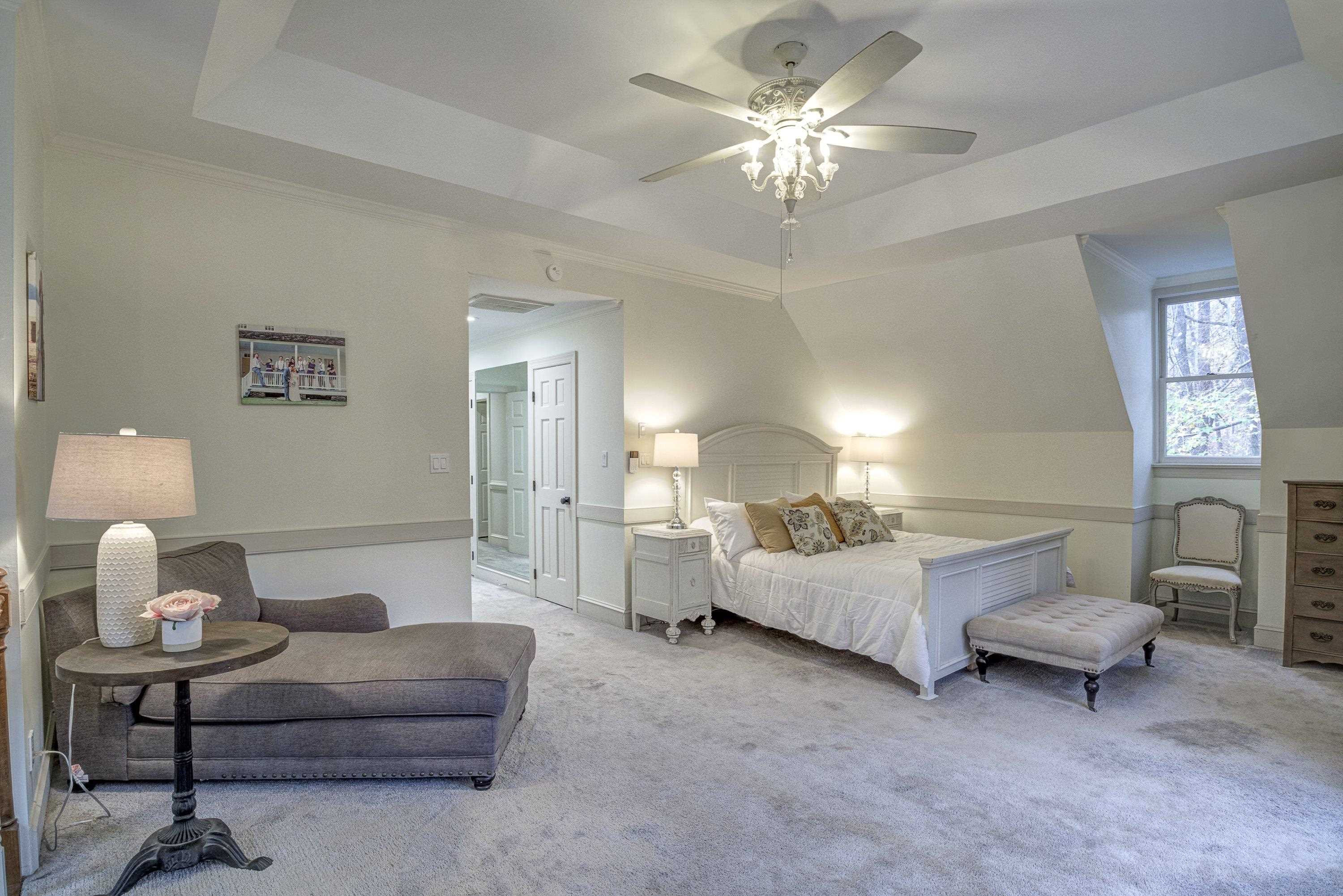 1413 Paumier Court Raleigh, NC 27615 - Photo 26 of 61 a spacious bedroom with a bed and a chandelier