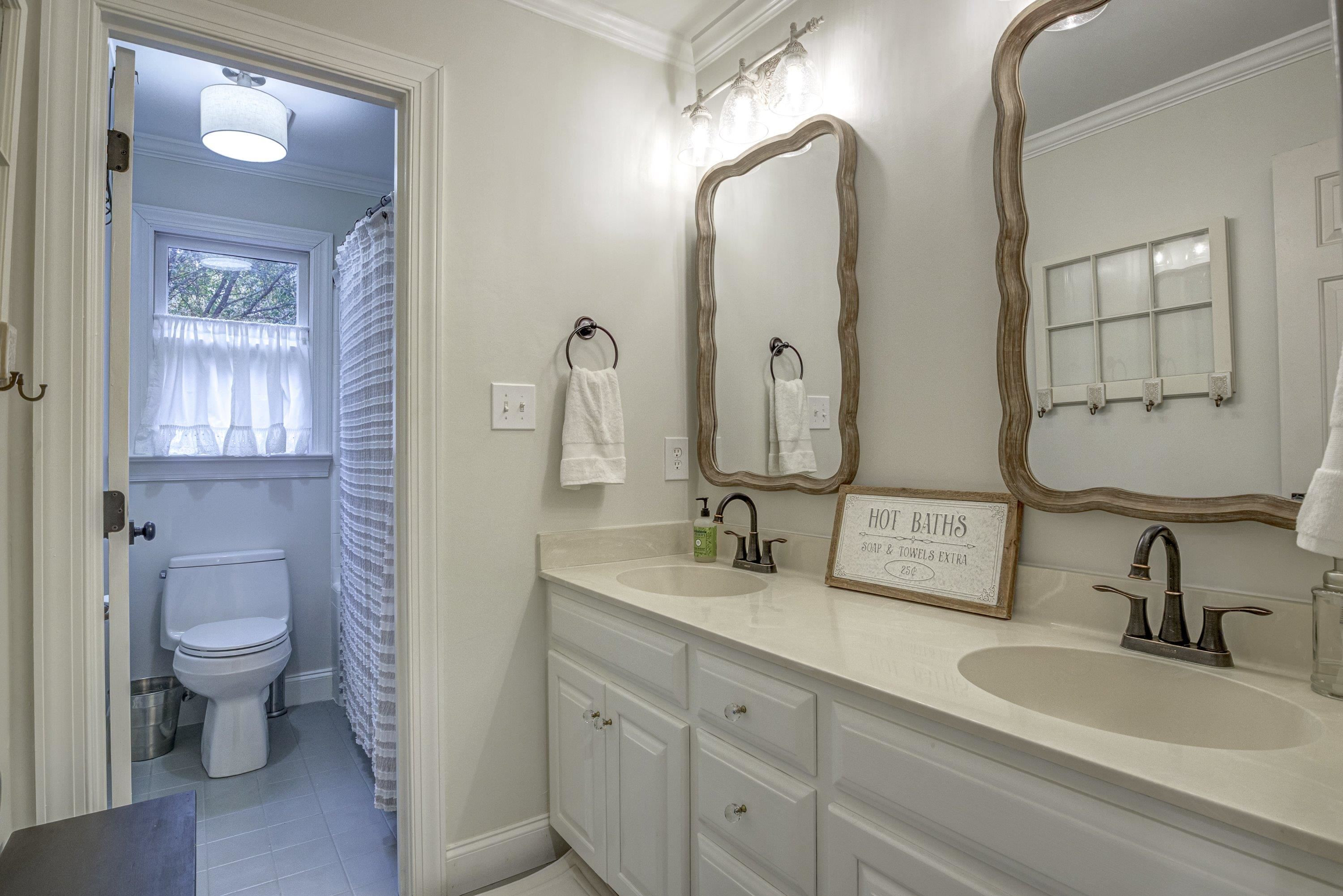 1413 Paumier Court Raleigh, NC 27615 - Photo 35 of 61 a bathroom with double vanity sinks a toilet a mirror and vanity