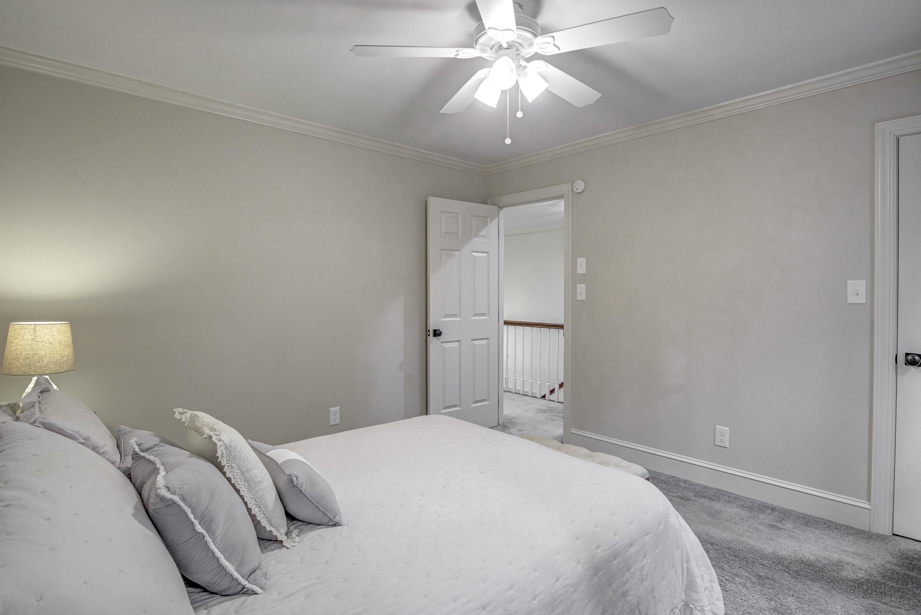 1413 Paumier Court Raleigh, NC 27615 - Photo 38 of 61 a bedroom with a large bed and a chandelier