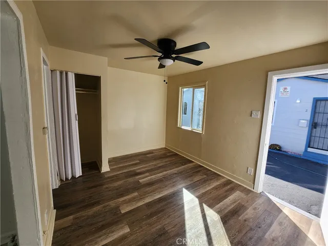 a view of a livingroom with wooden floor and a ceiling fan