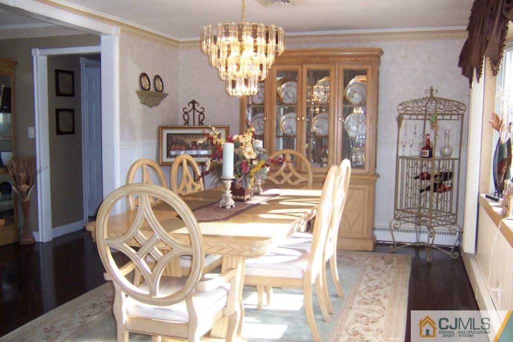 138 South Hill Road Colonia, NJ 07067 - Photo 4 of 25 a view of a dining room with furniture a chandelier and wooden floor