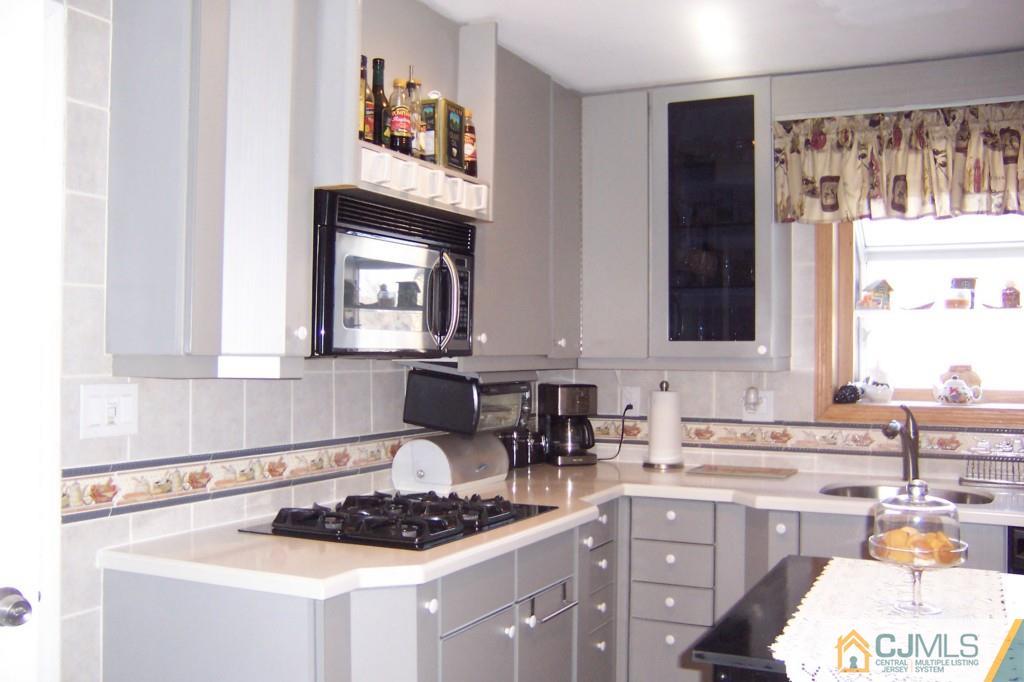 138 South Hill Road Colonia, NJ 07067 - Photo 6 of 25 a kitchen with a stove a sink and a microwave