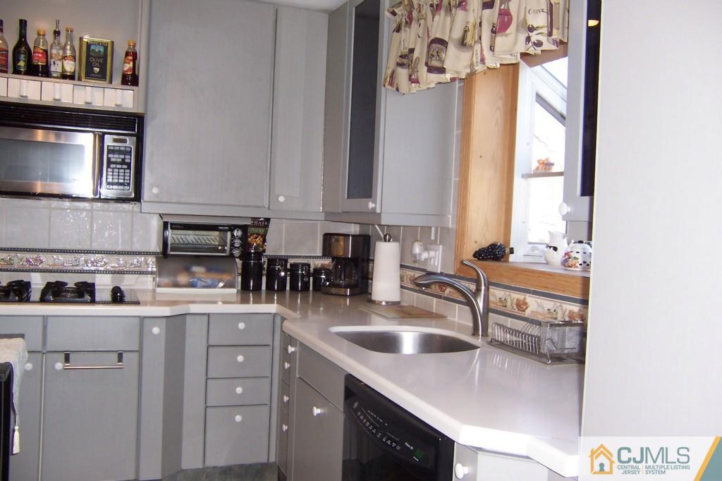 138 South Hill Road Colonia, NJ 07067 - Photo 8 of 25 a kitchen with stainless steel appliances granite countertop a sink a stove and a microwave