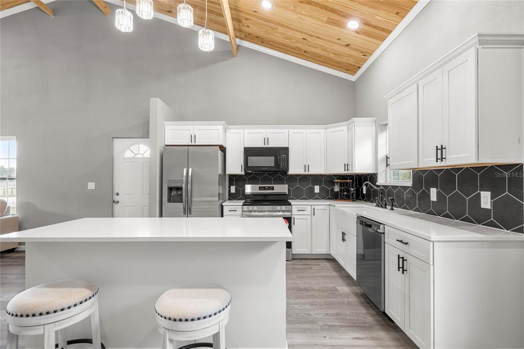 15010 Northeast 3rd Place Williston, FL 32696 - Photo 19 of 32 a kitchen with stainless steel appliances a white refrigerator a sink a stove and white cabinets