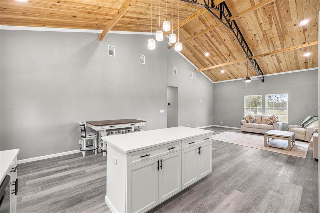 15010 Northeast 3rd Place Williston, FL 32696 - Photo 20 of 32 a open kitchen with a stove and white cabinets with wooden floor