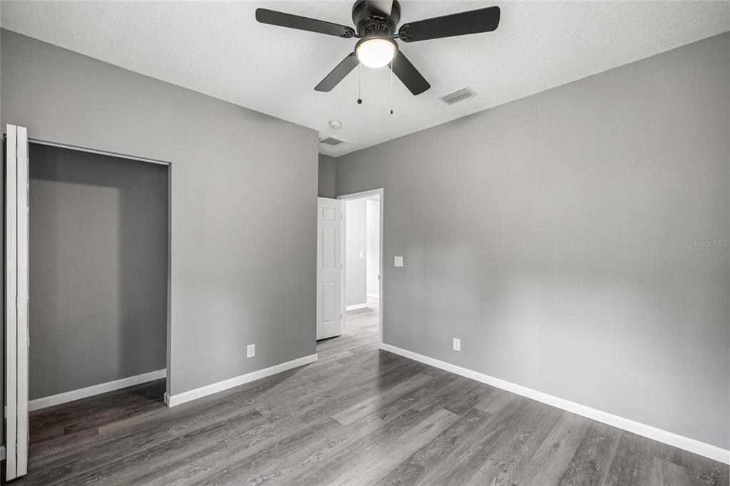 15010 Northeast 3rd Place Williston, FL 32696 - Photo 25 of 32 an empty room with wooden floor and ceiling fan