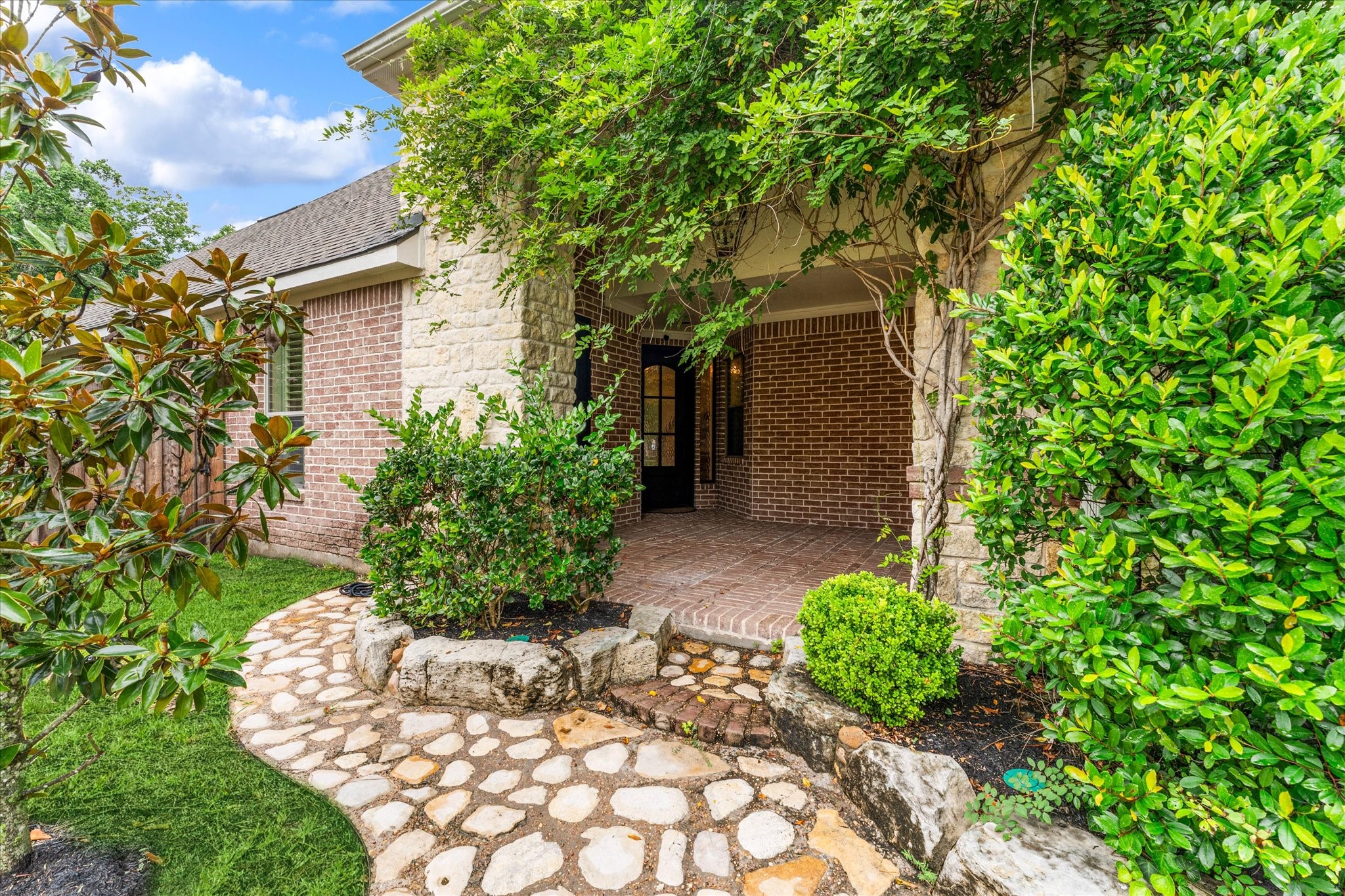 28331 Hollow Springs Lane Spring, TX 77386 - Photo 7 of 49 Beautifully maintained home featuring a welcoming covered front porch that offers convenient access to the garage. The property is also equipped with a functional sprinkler system for easy lawn maintenance.