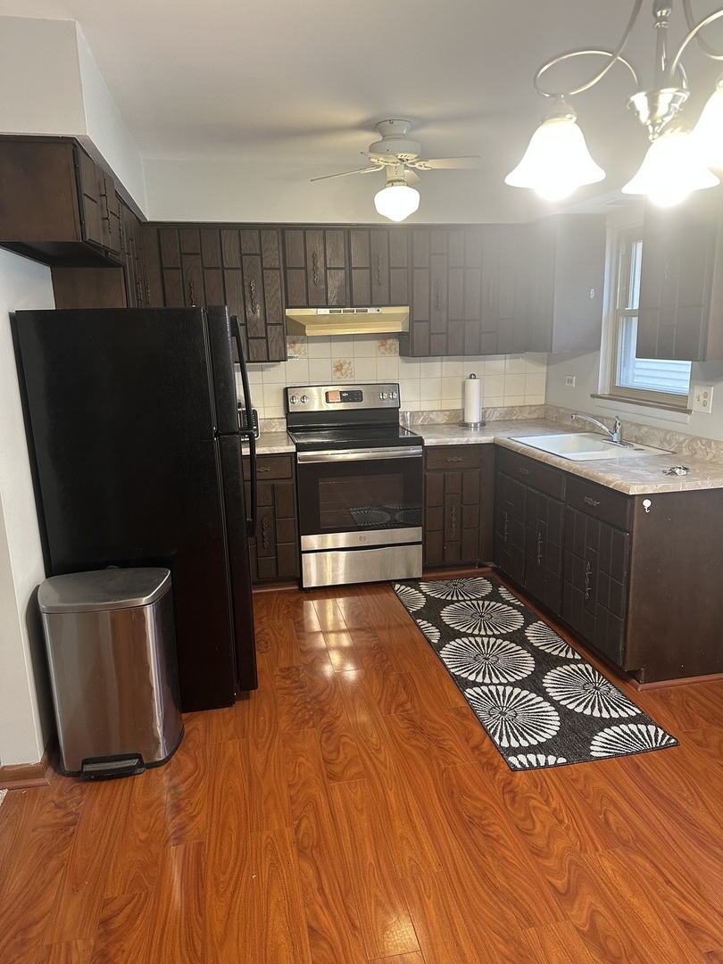 2113 West Montrose Avenue, Unit 2F Chicago, IL 60618 - Photo 2 of 8 a kitchen with granite countertop a refrigerator and a stove top oven