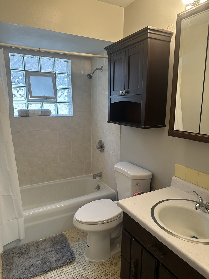 2113 West Montrose Avenue, Unit 2F Chicago, IL 60618 - Photo 4 of 8 a bathroom with a toilet a sink and bathtub