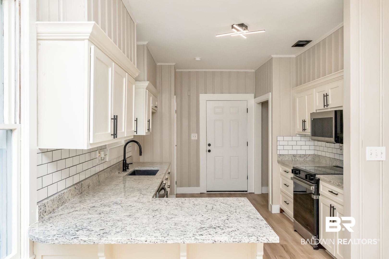 555 Michigan Avenue Mobile, AL 36604 - Photo 13 of 28 Kitchen with white cabinetry, sink, kitchen peninsula, appliances with stainless steel finishes, and backsplash