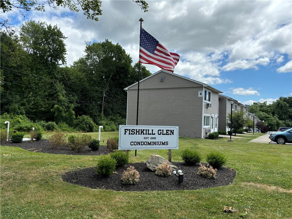 Community / neighborhood sign featuring a lawn