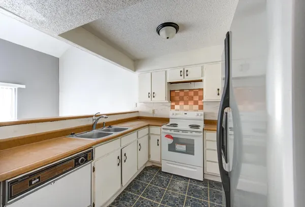 a kitchen with a sink stove and refrigerator