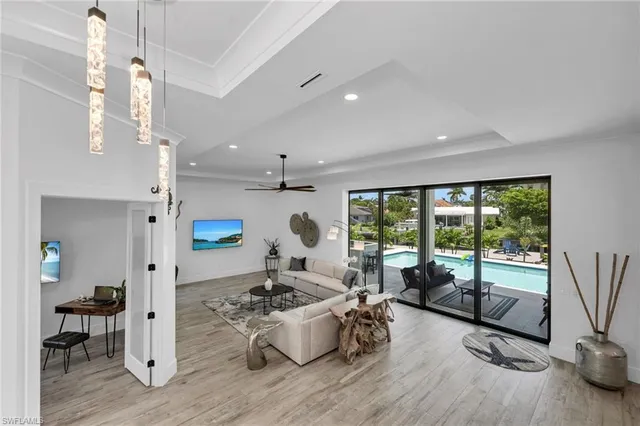 a living room with furniture large window and wooden floor