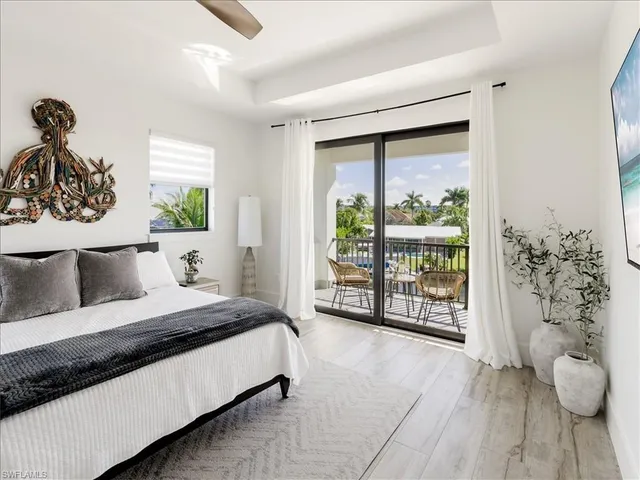 a bedroom with a large bed and a potted plant
