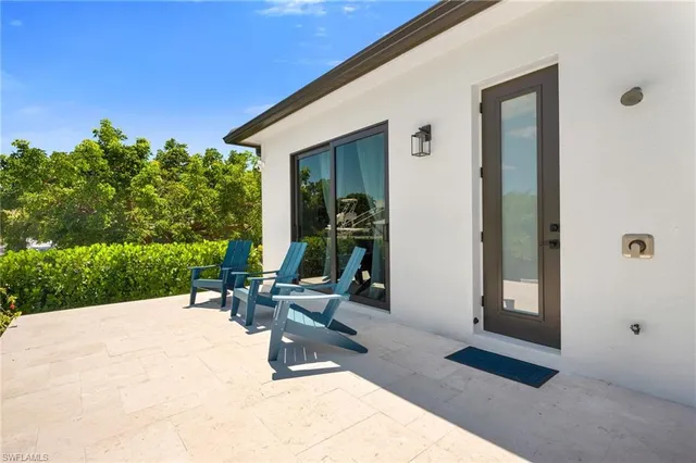 a view of a patio with a table and chairs and potted plants