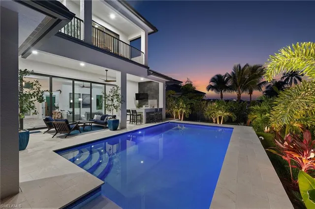 a view of a house with pool and sitting area