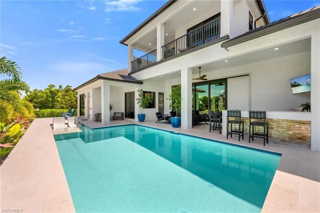 a view of house with swimming pool and sitting area
