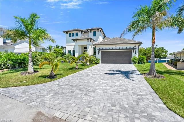 a front view of a house with a yard and potted plants