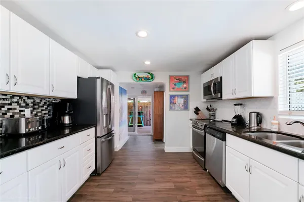 a kitchen with stainless steel appliances a refrigerator sink and cabinets