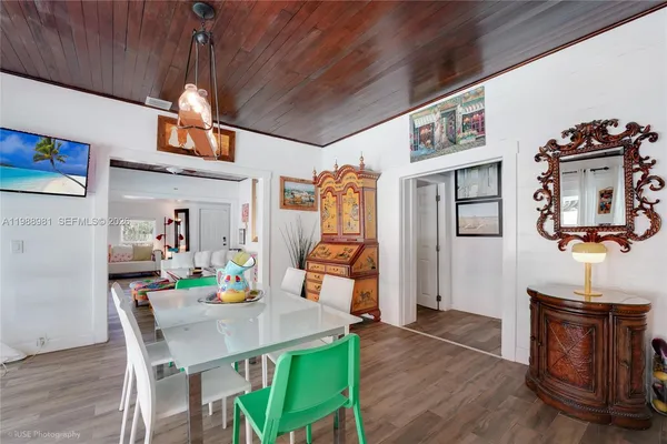 a view of a dining room with furniture a chandelier and wooden floor