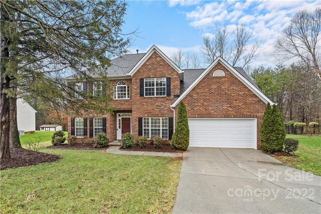 5677 Berry Ridge Drive Harrisburg, NC 28075 - Photo 1 of 24 a front view of a house with a yard and trees