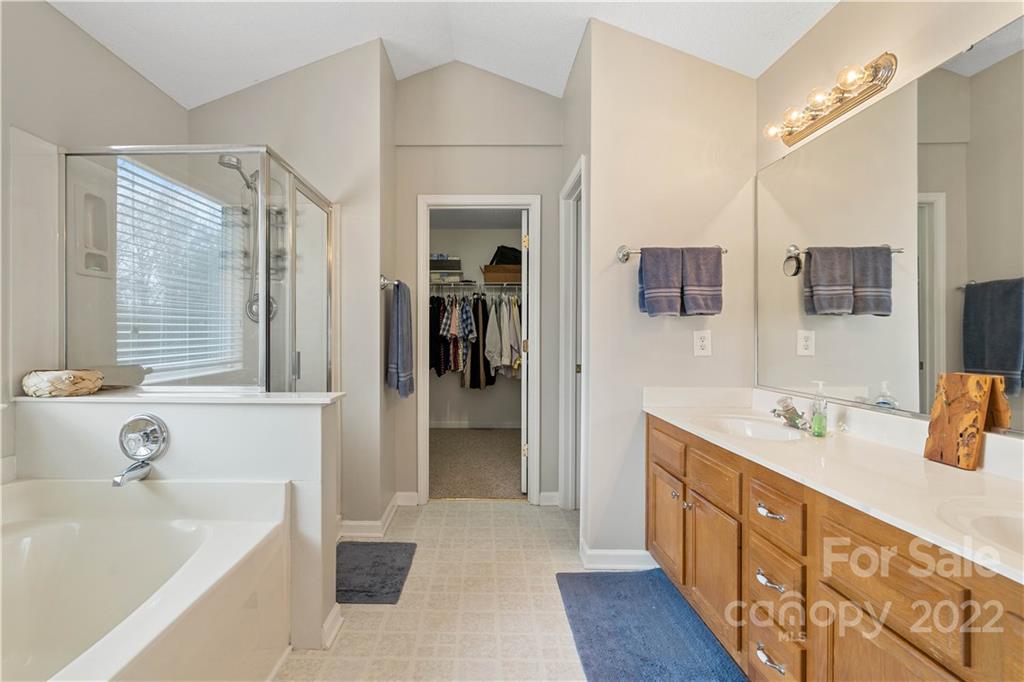5677 Berry Ridge Drive Harrisburg, NC 28075 - Photo 16 of 24 a bathroom with a tub sink and mirror