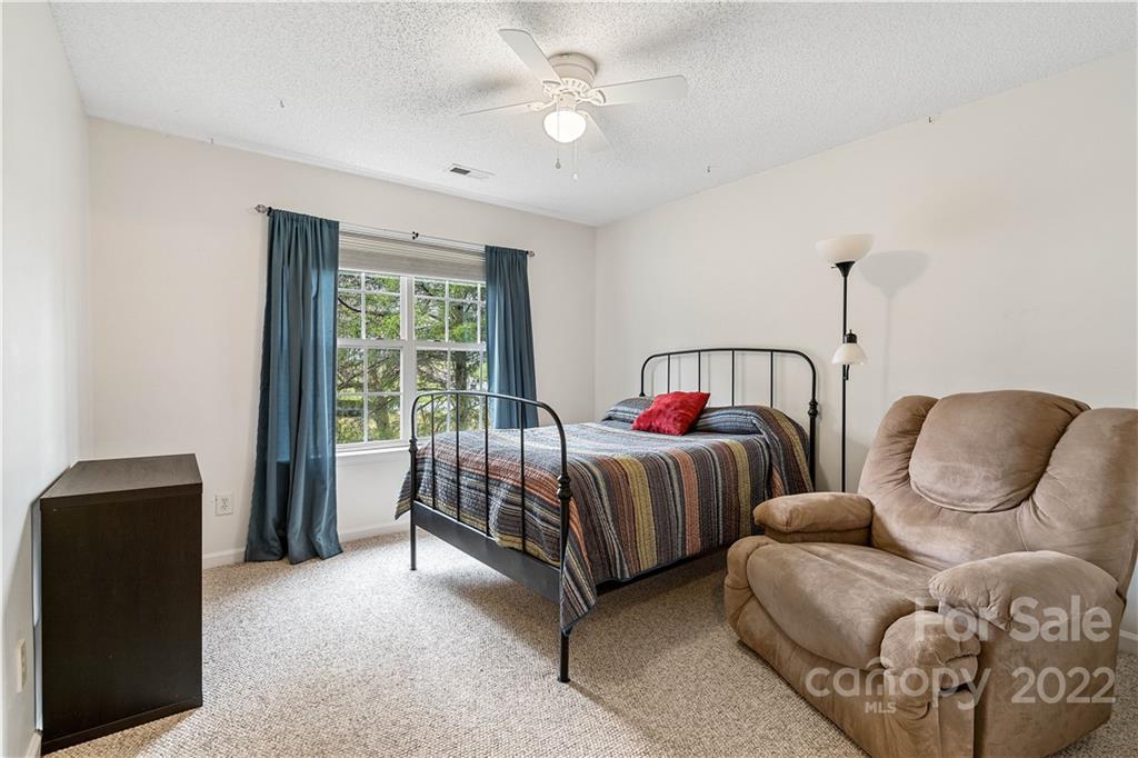 5677 Berry Ridge Drive Harrisburg, NC 28075 - Photo 19 of 24 a bedroom with two beds and a chandelier