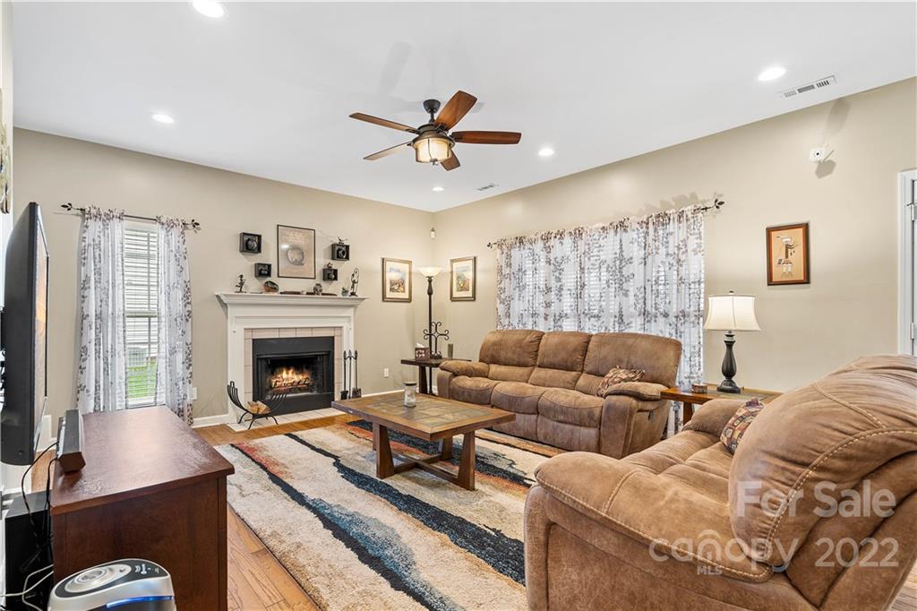 5677 Berry Ridge Drive Harrisburg, NC 28075 - Photo 4 of 24 a living room with furniture a flat screen tv and a fireplace