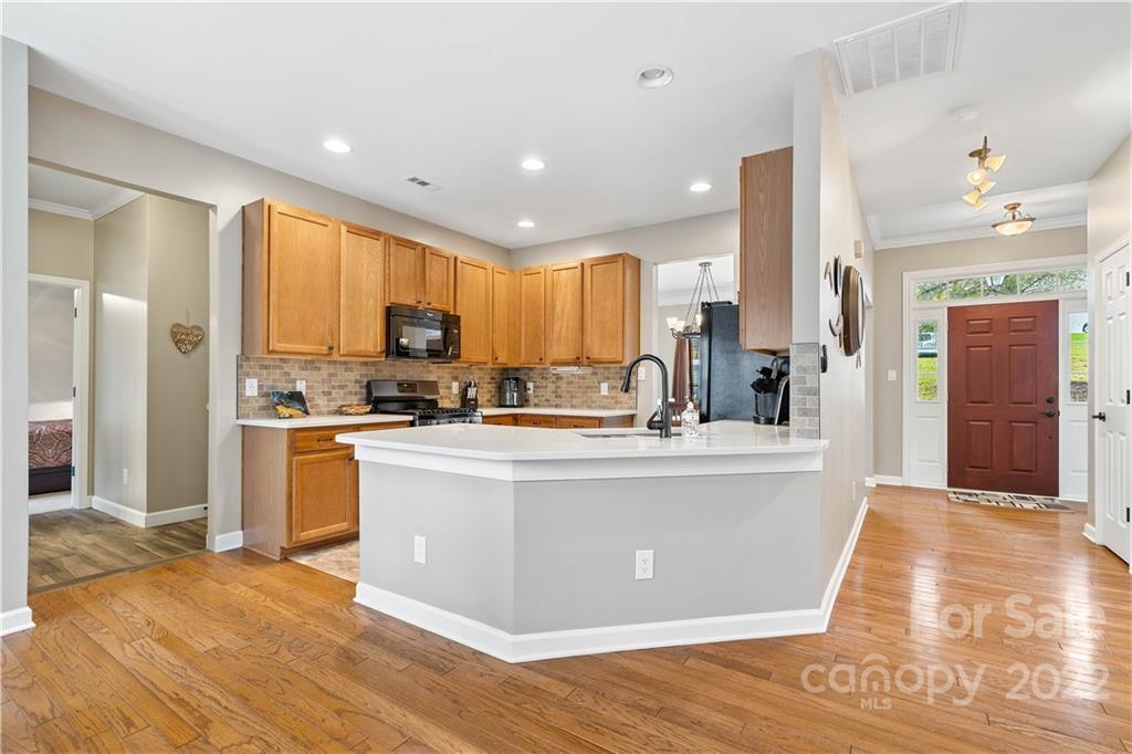 5677 Berry Ridge Drive Harrisburg, NC 28075 - Photo 7 of 24 a view of kitchen with stainless steel appliances granite countertop a stove a sink a refrigerator and cabinets
