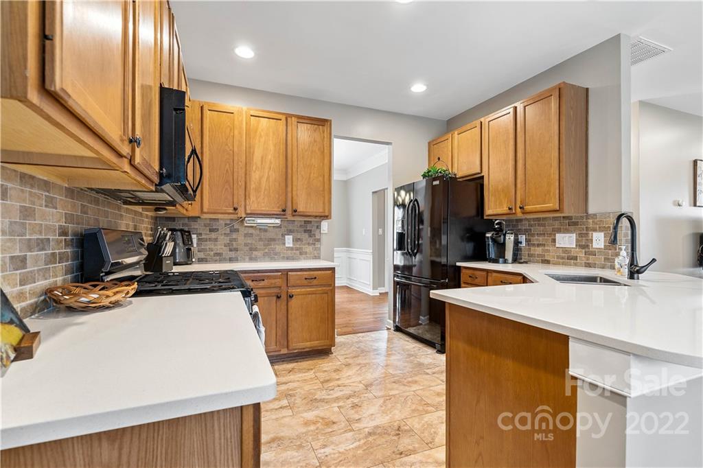 5677 Berry Ridge Drive Harrisburg, NC 28075 - Photo 8 of 24 a kitchen with stainless steel appliances a sink stove and refrigerator