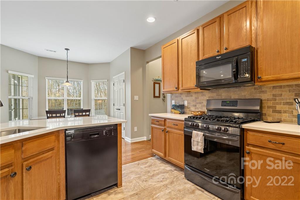5677 Berry Ridge Drive Harrisburg, NC 28075 - Photo 10 of 24 a kitchen with stainless steel appliances granite countertop a stove a sink and a microwave