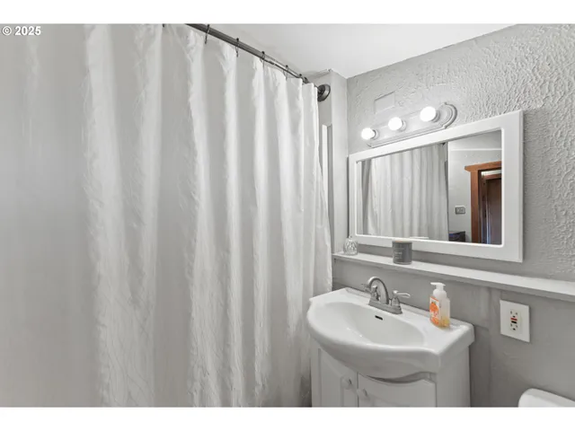 a bathroom with a sink a mirror and a shower curtain