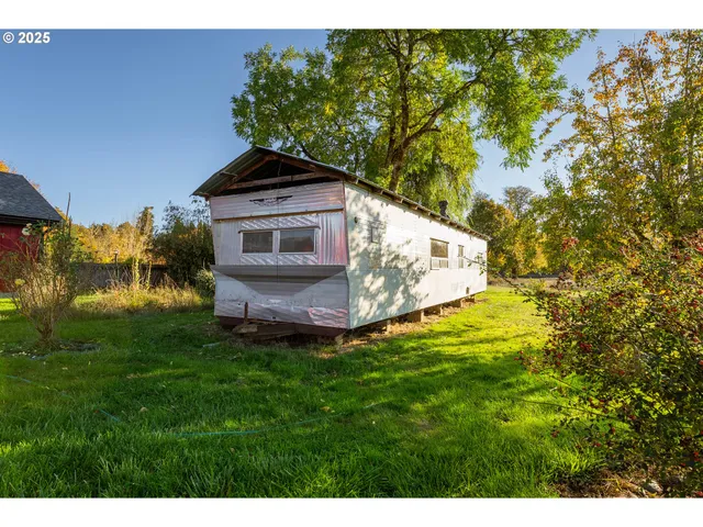 a white house with a big yard and large trees