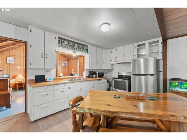 a kitchen with stainless steel appliances kitchen island granite countertop a refrigerator a sink dishwasher with a dining table and chairs