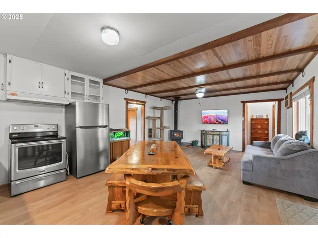 a living room with furniture a flat screen tv and a refrigerator