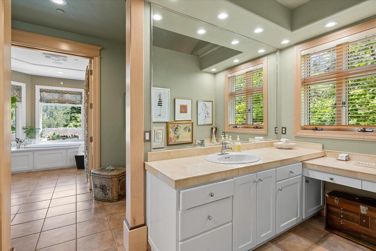 500 Ashland Loop Road Ashland, OR 97520 - Photo 29 of 67 a spacious en suite bathroom with a granite countertop sink mirror and bathtub