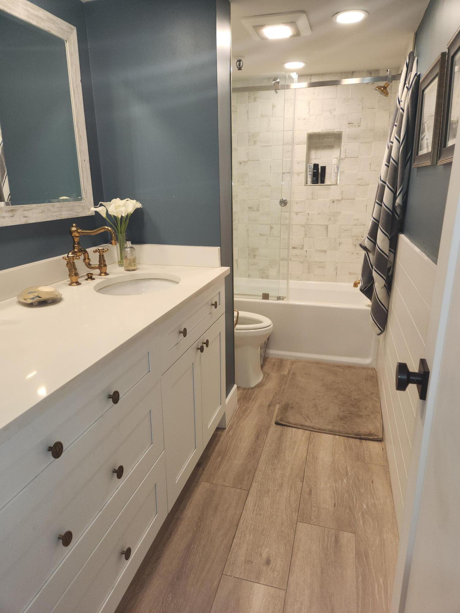 899 Jeffery Street, Unit 4150 Boca Raton, FL 33487 - Photo 13 of 38 a bathroom with a tub sink toilet and a mirror