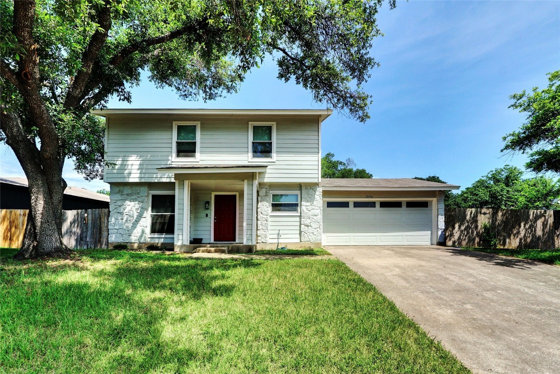 a front view of house with yard and trees in the background