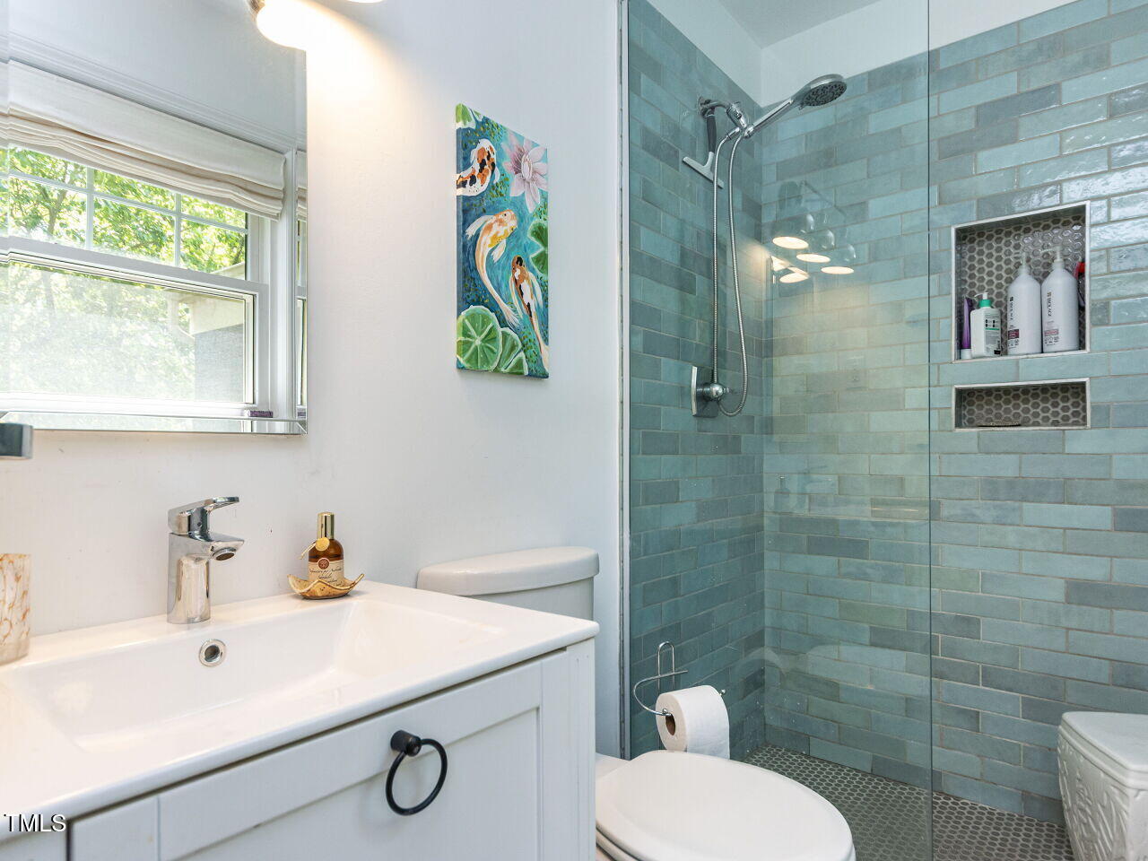 713 Macon Place Raleigh, NC 27609 - Photo 20 of 36 a bathroom with a sink toilet and shower
